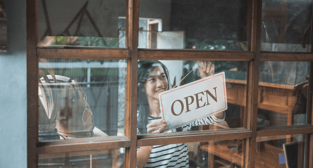 Business owner with open sign